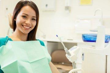 woman sitting in dental exam chair smiling l dental cleanings smyrna ga