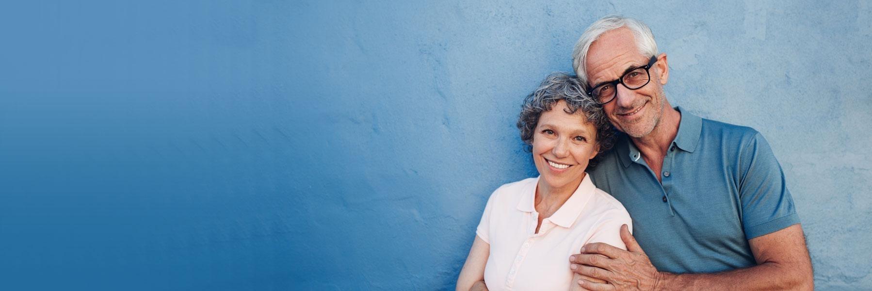 older couple with blue background smiling l root canal therapy smyrna ga