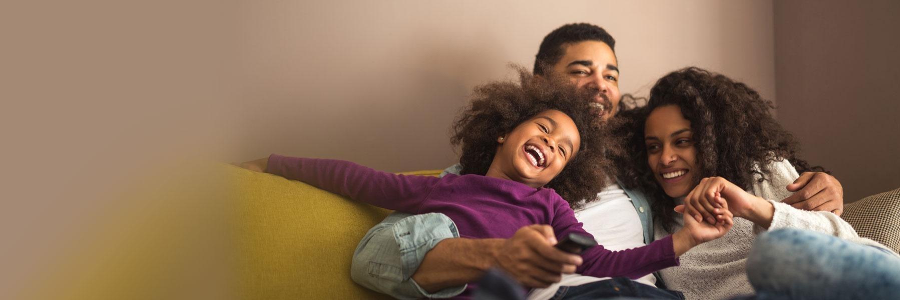 family of three hugging on couch l dentist near me smyrna ga