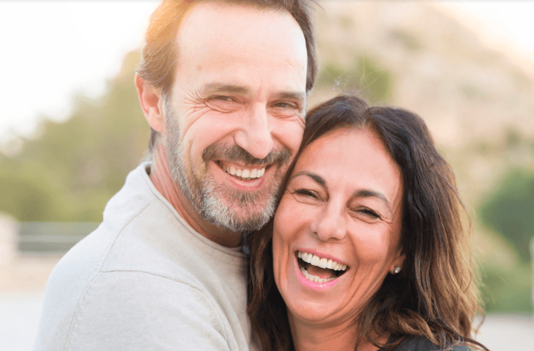 Man hugging his wife while smiling