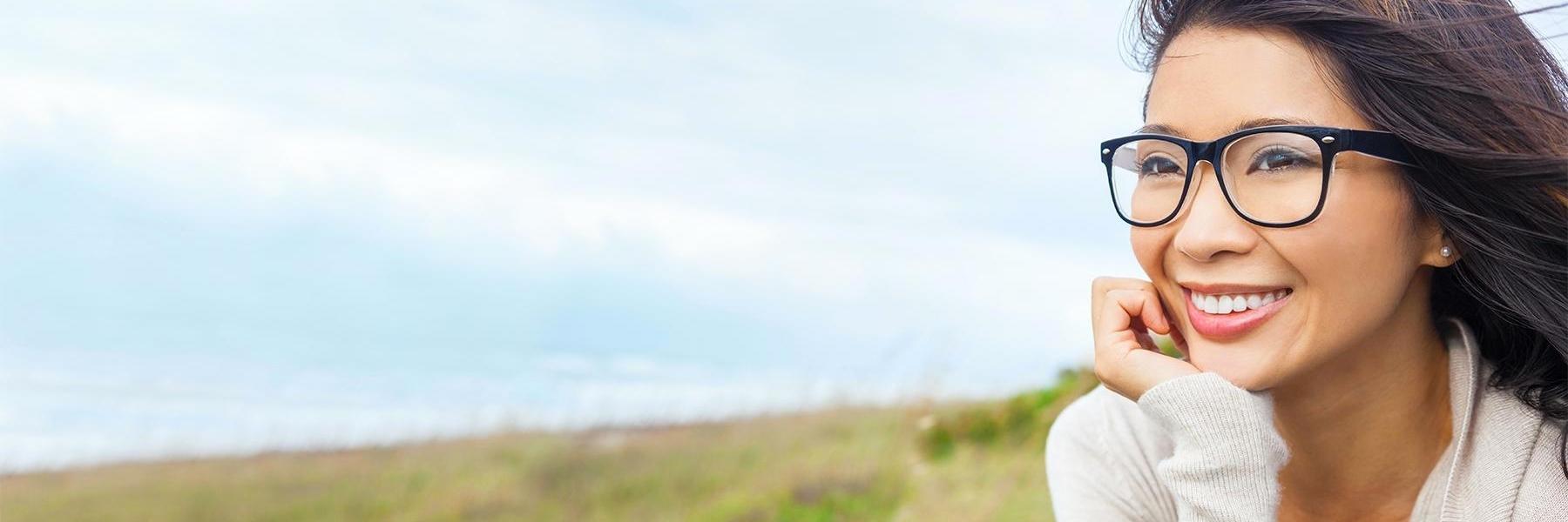 woman with glasses smiling outside | smyrna dentist